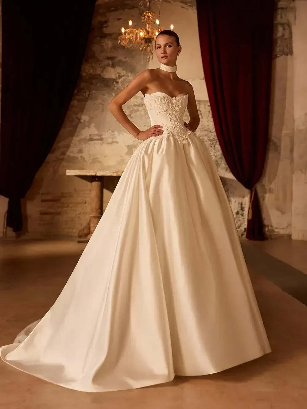 model is wearing a strapless ball gown wedding dress