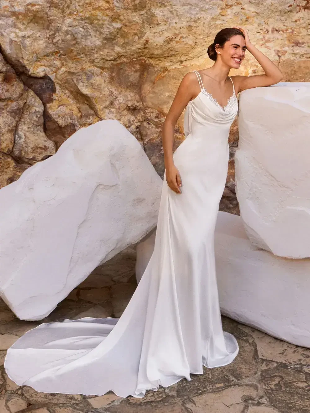model is wearing a sleeveless sheath wedding dress