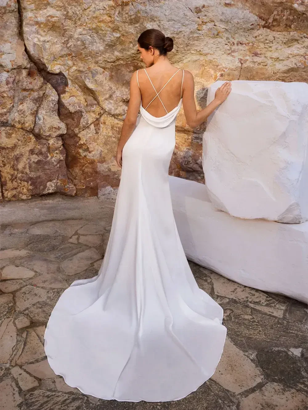model is wearing an open back sleeveless wedding dress