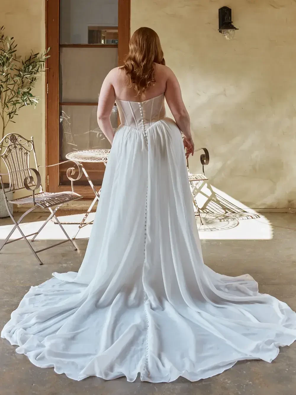 model is wearing a strapless plus size wedding dress